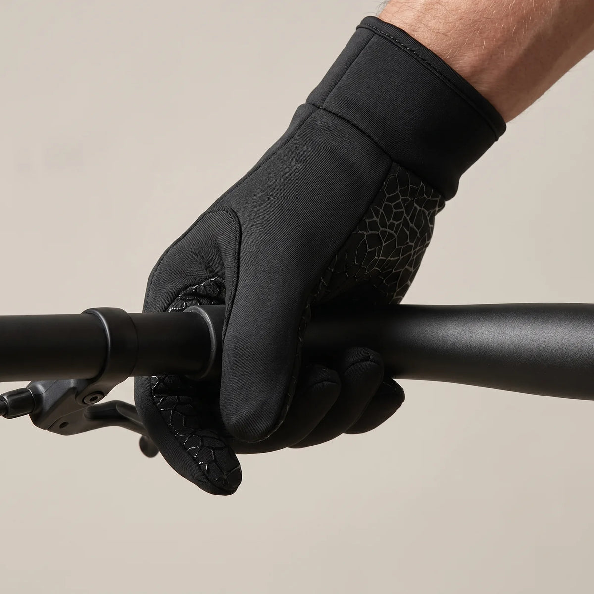Behandschuhte Hand greift den Lenker, Griffmuster liegt am Rohr an