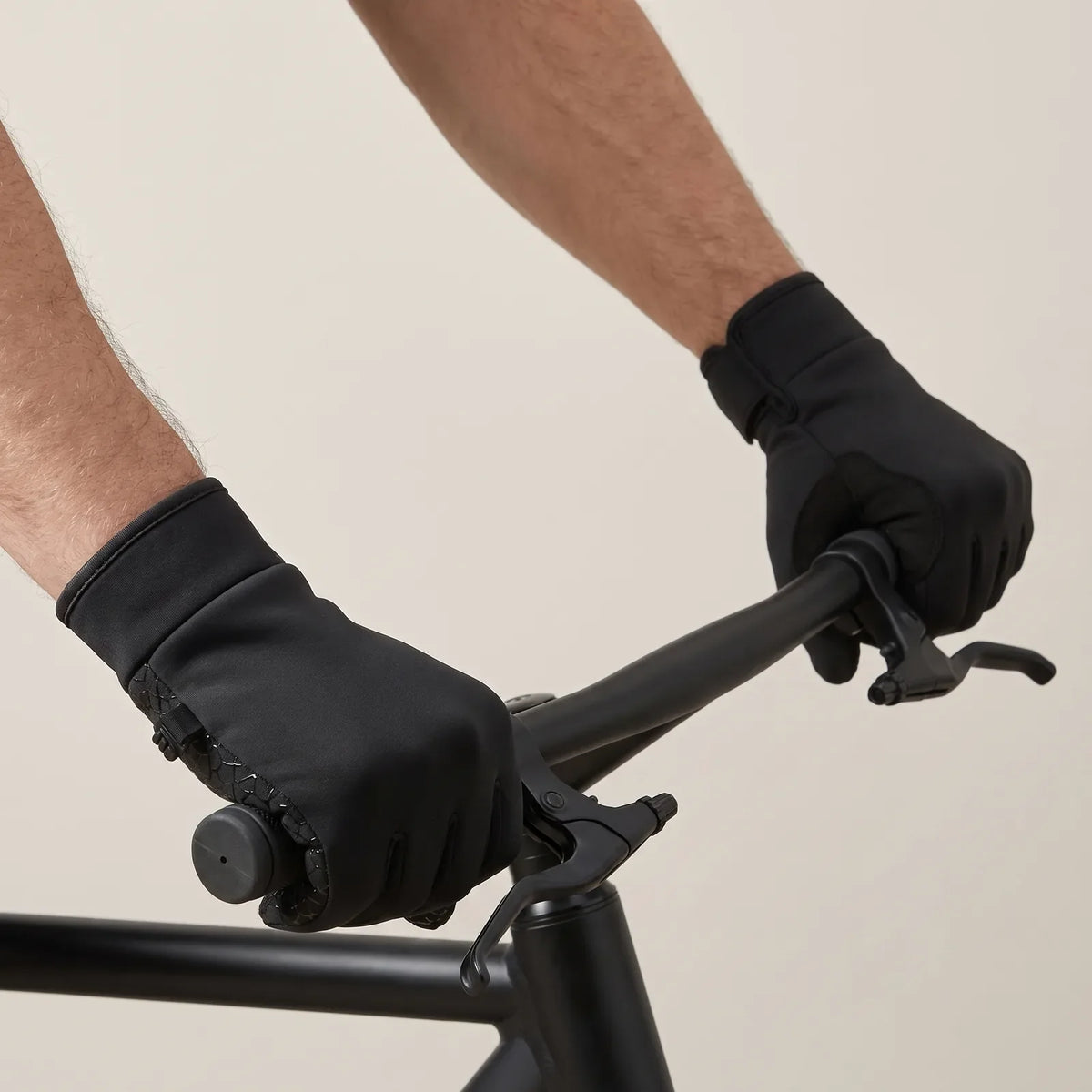 Both gloved hands on the handlebars
