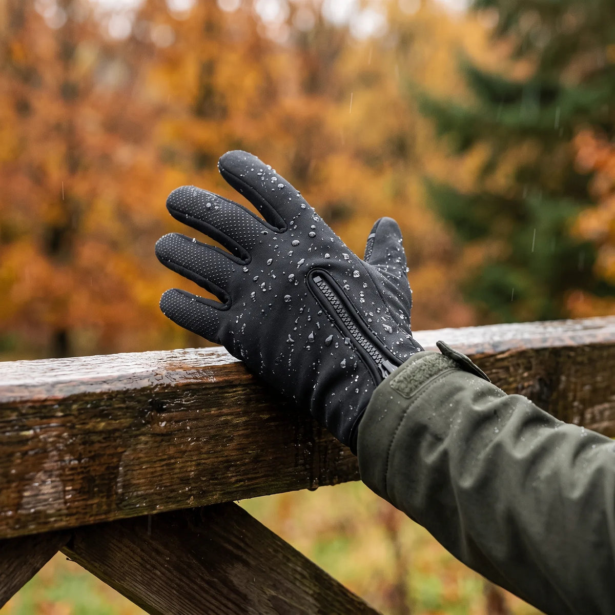 Water beading on the Grip heated glove resting on a wet wooden gate in autumn