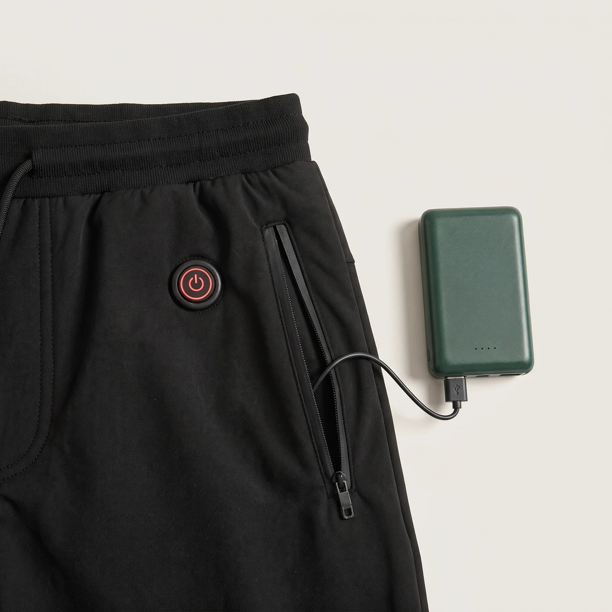 Heat button below the waistband and pocket with the BergHeat Power Bank plugged in