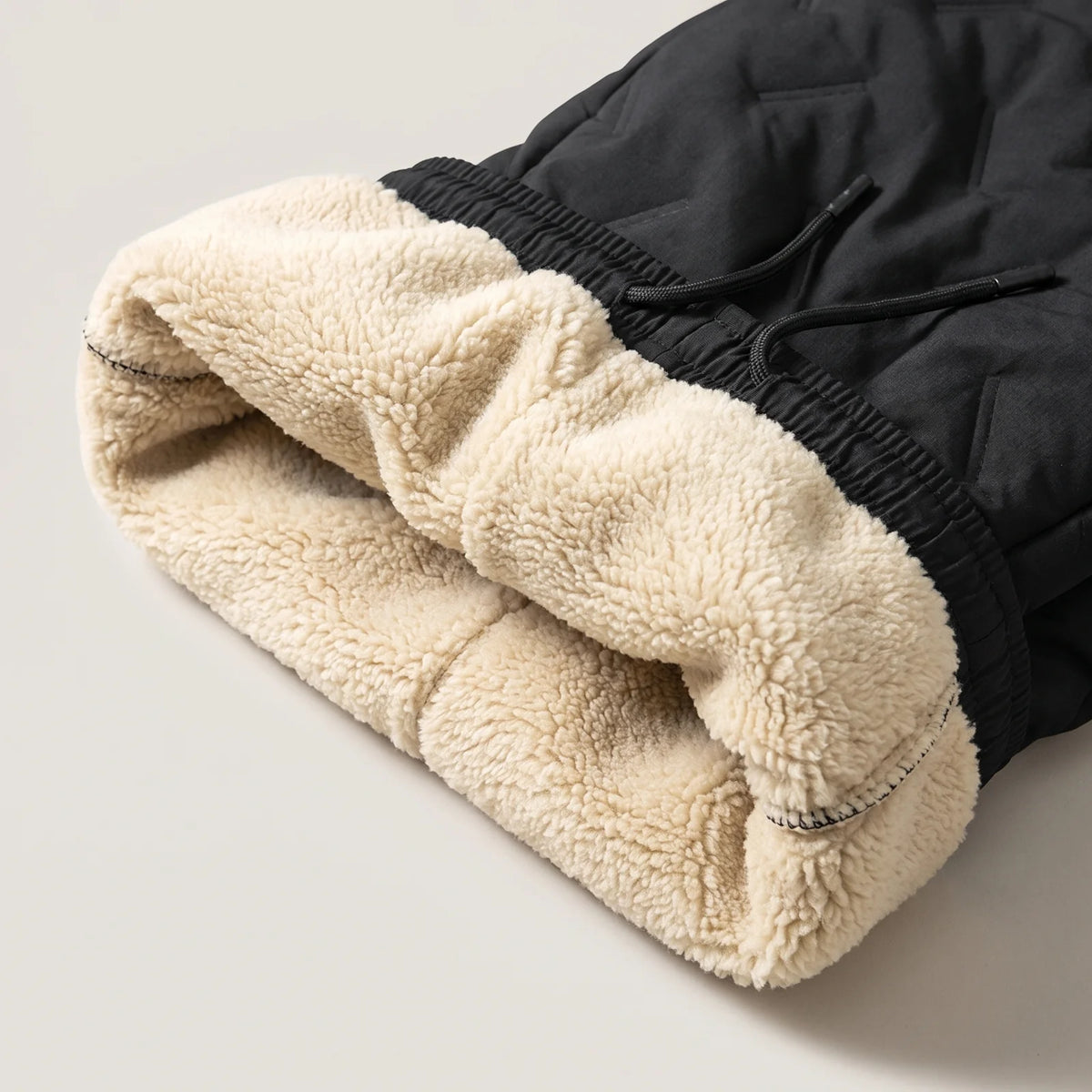 Folded waistband: black outer fabric, thick cream sherpa lining inside