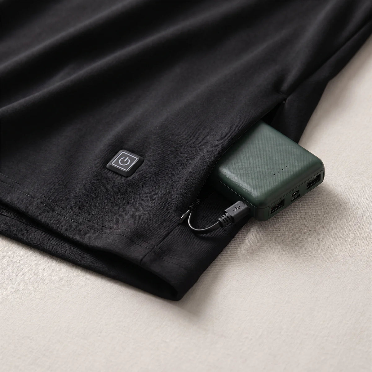 Heat button at the hem and zip pocket with the BergHeat Power Bank plugged in